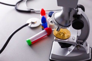 Coin crypto currency bitcoin lies on the microscope background theme of the gold exchange pyramid for money due to the rise or fall of the exchange rate.