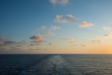 Naklejka na ściany i meble Sunset on the sea with wake of the ship