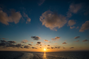 Obraz premium Sunset on the sea with wake of the ship