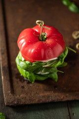 Vegan tomatoe, burger with vegan mozzarella and basil. Dark, rustic background. 