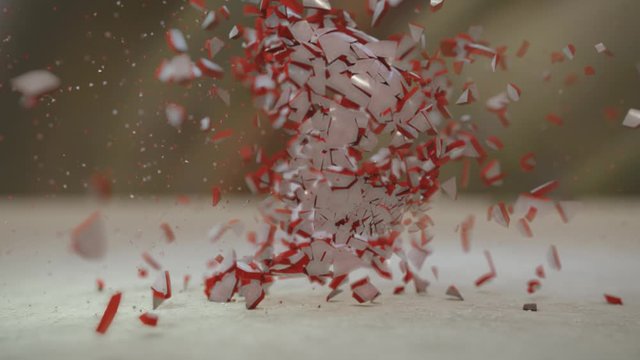 Slow motion video of bullet destroying and shattering a red and white glass sphere. 3D animation. Anger, destruction, fragility.