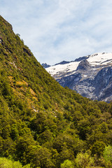 Valley between snowy mountains and hills on the road from Fiordland. South Island, New Zealand