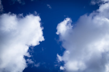 White clouds in a dark blue sky foreshadowing rain or thunder