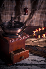 Old vintage manual coffee grinder with old books on wooden background