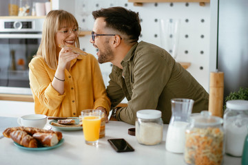 Young couple making breakfast at home. Loving couple eating together 