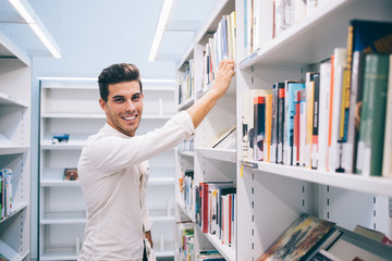 Happy student spending time in library