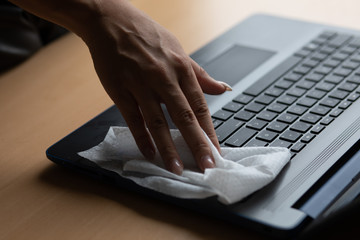 Work from home - cleaning and disinfecting laptop computer with wet wipes