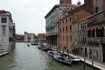Cityscape with historical facades, boats and canals in Venice.