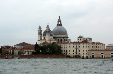 Fototapeta na wymiar Cityscape with Santa Maria della Salute church with historical facades and adriatic sea in Venice. View from the adriatic sea