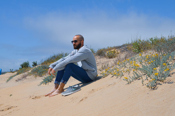 Chico sentado en la playa de Islantilla, Huelva, España. 