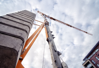 Bottom view of Tower crane against cloudy sky