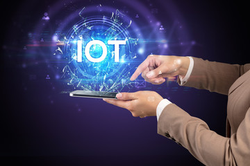 Close-up of a touchscreen with IOT abbreviation, modern technology concept