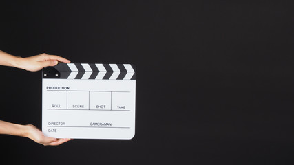 TWO Hands is holding white Clapperboard or movie slate. it use in video production ,film, cinema industry on BLACK background.