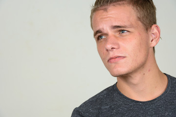 Fototapeta premium Face of young handsome man with blond hair thinking