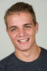 Face of happy young handsome man with blond hair smiling