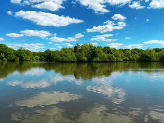Obraz na płótnie Canvas Lake view with blue sky reflection on water, England.