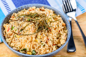 Fried Rice in a blue texured bowl on a wooden table.