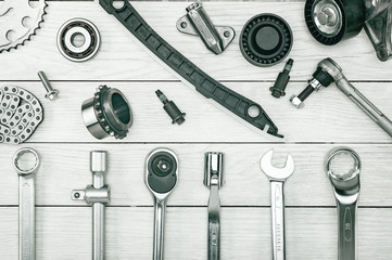 The layout of auto parts and car repair tools. Wooden white background.