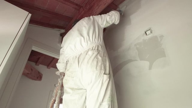 wall painter working in a building site with mask