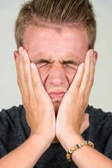 Face of stressed young man with blond hair with looking frustrated