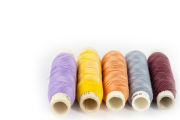 Fototapeta na wymiar Coloured bobbins of thread on white background 