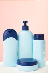 Blue cosmetic bottles on pink background. Top view