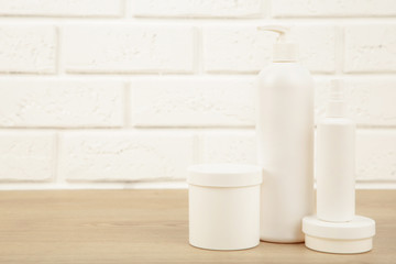 White cosmetic bottles on white background. Top view