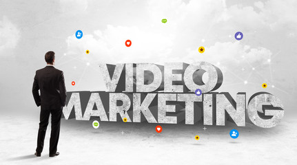 Young businessman standing in front of VIDEO MARKETING inscription, social media concept