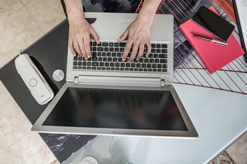 Fototapeta na wymiar Faceless freelancer using laptop while working at home