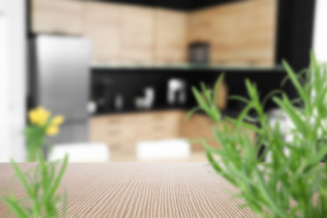 Wooden table with plants in modern kitchen interior