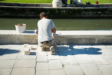 lavoratori restauro muretto sul lago nelle città d’arte in Italia a Padova in prato della valle