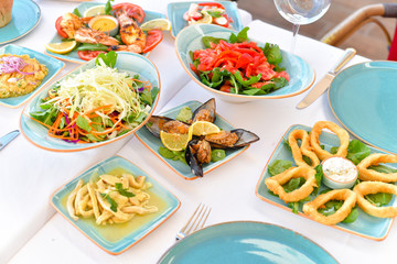 appetizers with yogurt, tomatoes, cheese, lemon, greens, mussels, olives, snacks on white background, ready for service, should be used as background.