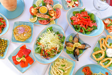 appetizers with yogurt, tomatoes, cheese, lemon, greens, mussels, olives, snacks on white background, ready for service, should be used as background.