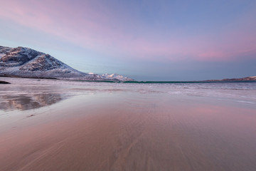 Naklejka premium Amazing sunrise with amazing magenta color over sand beach. Tromso, Norway . Polar night. long shutter speed