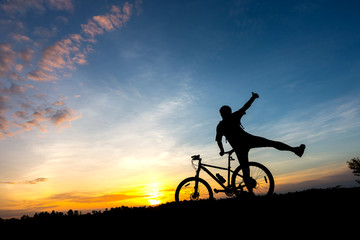 Action of  cyclist and Bicycle silhouettes on the dark background of sunsets