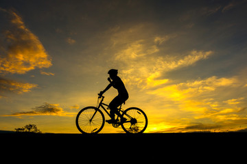 Action of  cyclist and Bicycle silhouettes on the dark background of sunsets