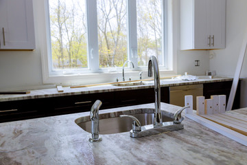 Modern domestic cabinets with new appliances and sink in kitchen