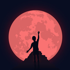 Silhouette of a boy with round red moon on the background.