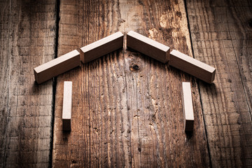 Biznesowa koncepcja dom z klocków ułożony na starych deskach © piotrszczepanek