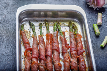 green asparagus with cooked ham on a black background