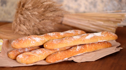Fresh baguette on wooden table, close up.