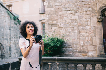 Travelling woman with photo camera standing on balcony of medieval building