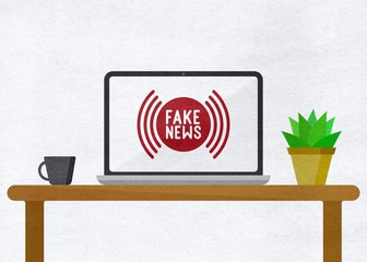 "Fake news" Laptop on a table with a mug and a plant 