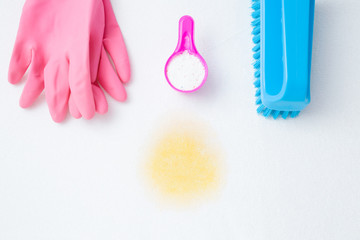 Pink rubber protective gloves, scoop of washing powder and brush on white surface. Housewife things...