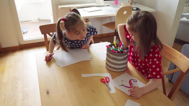 little girls draw on paper at home during a pandemic