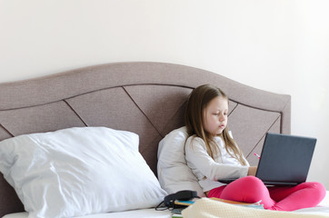 The girl is engaged in distance learning on a computer. Selective focus, horizontal image.