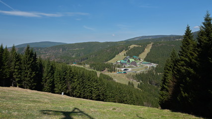 Fototapeta premium Mountain huts on a road at mountain pass on a sunny cloudless spring day.