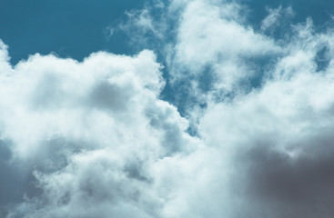 Fluffy clouds cover the summer blue sky