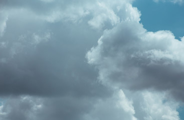 Fluffy clouds cover the summer blue sky