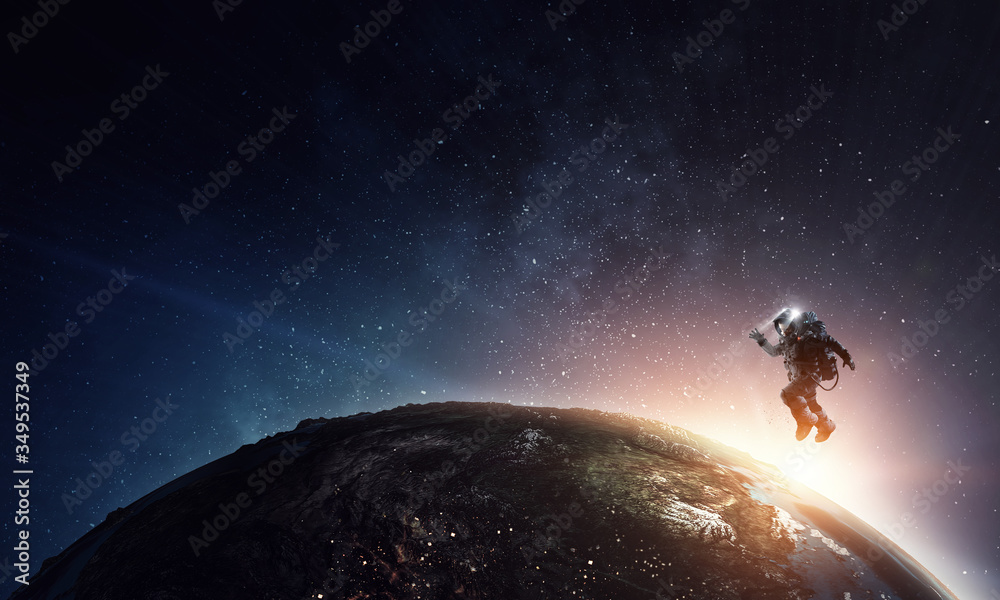 Wall mural astronaut in space on planet orbit.